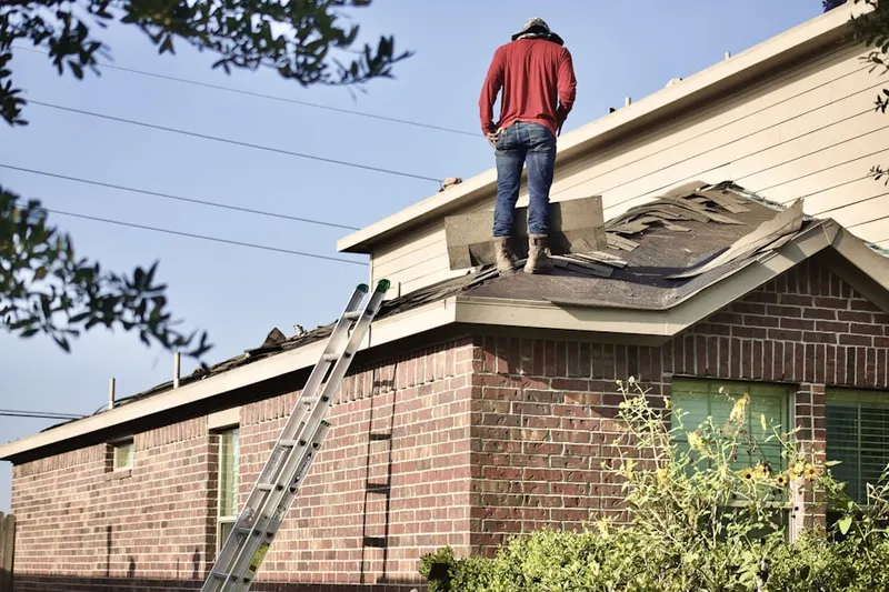 Professional roofer working on a residential roof in Malden Center